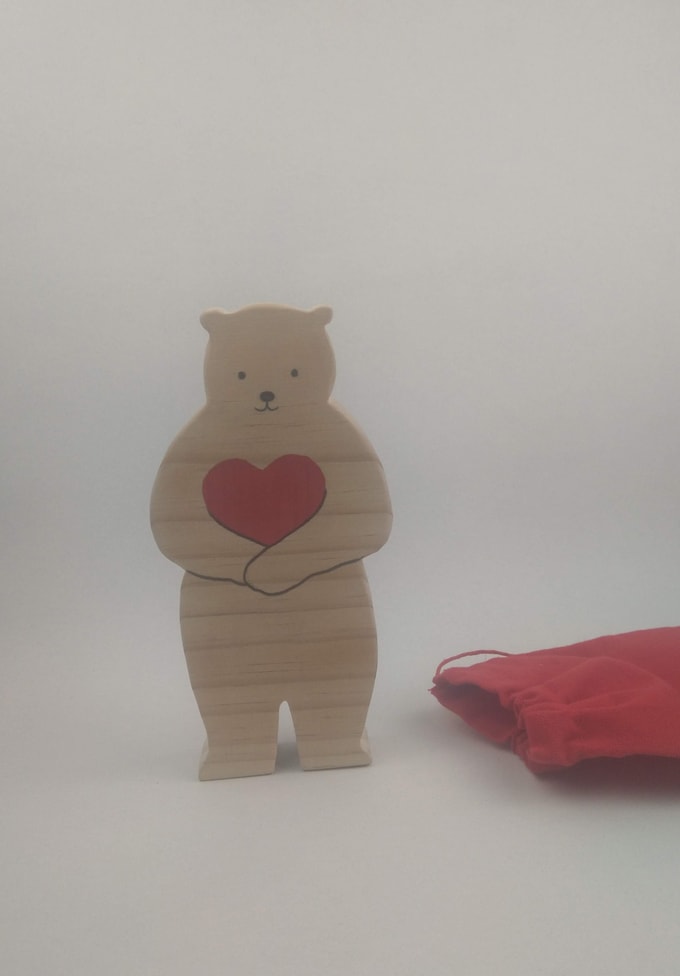 ours en bois debout tenant un coeur rouge dans ses pattes