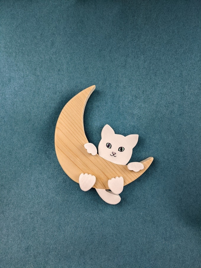 chat blanc grimpant sur lune bois